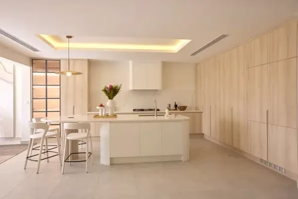 Open-plan kitchen and dining area with natural light in Al Hamra townhouse renovated by Tunde Hendricks