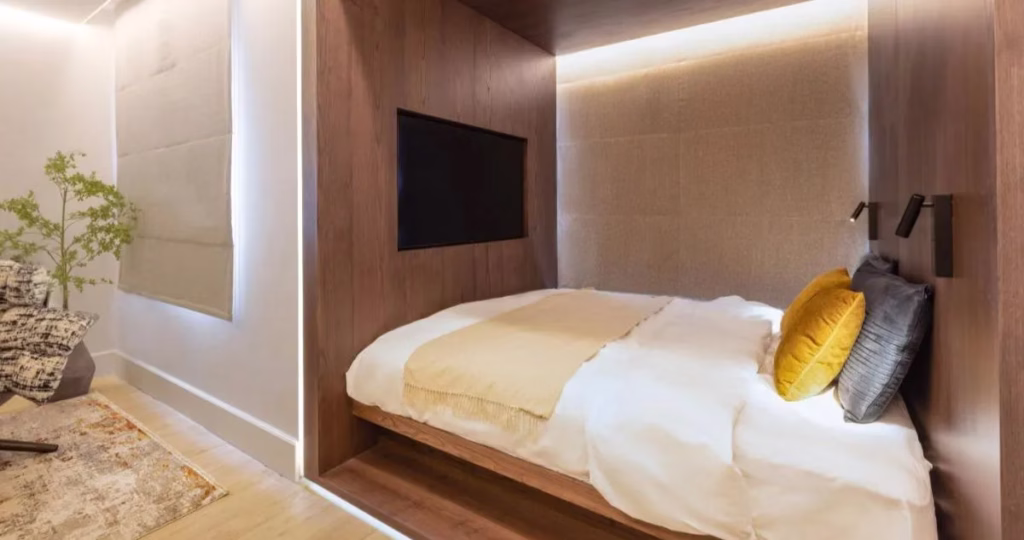 Light neutral bedding layered with textured throws and pillows in a cozy bedroom designed by Tunde Hendricks Design
