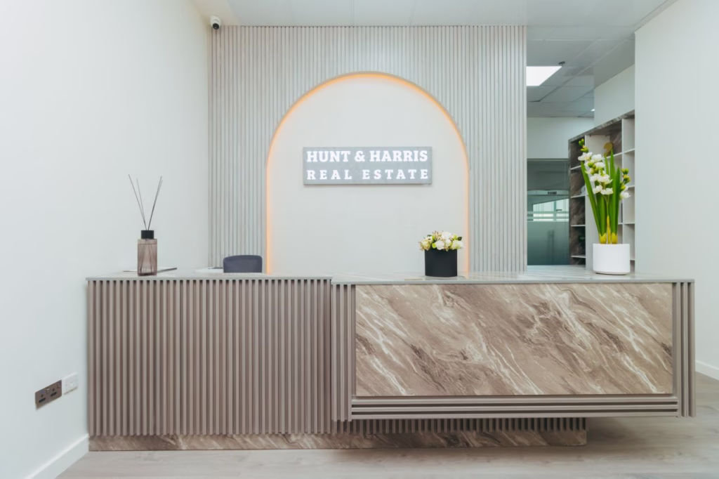 Modern office reception area designed by Tünde Hendricks Design in Ras Al Khaimah, featuring a sleek desk, comfortable seating, and welcoming lighting.