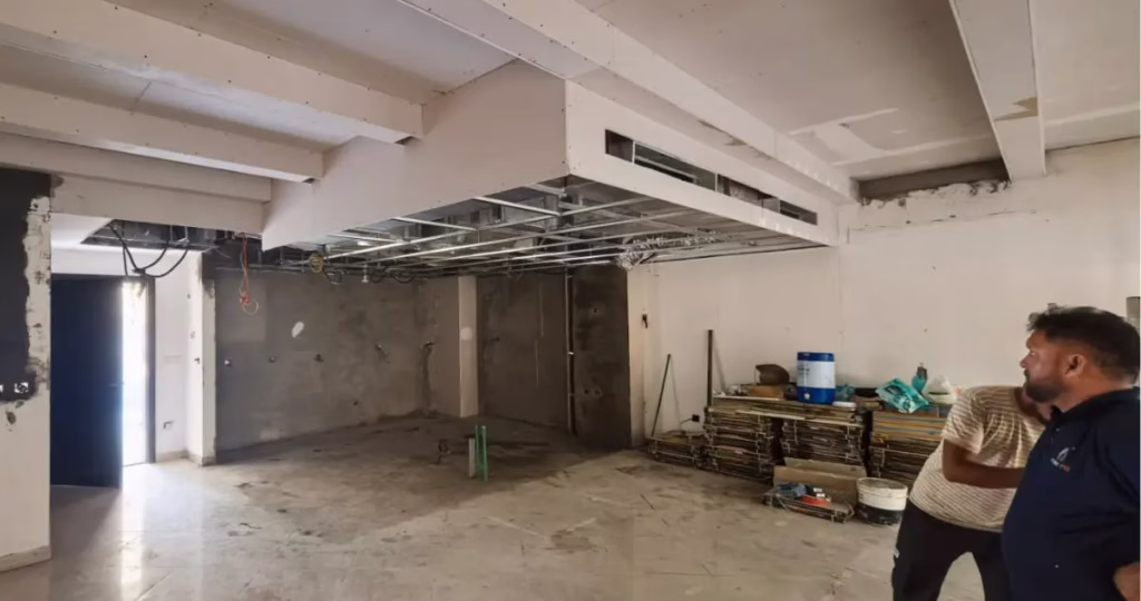 An active kitchen construction and fit-out site featuring exposed ceiling framing and AC ductwork during the Villa Barefoot renovation project by Tünde Hendricks Design.