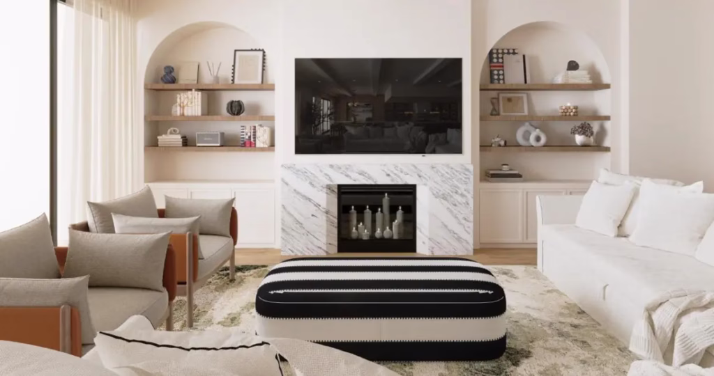 A luxury Mediterranean-style living room with arched alcoves, built-in shelving, a marble fireplace, and a black and white striped ottoman from the Villa Barefoot family renovation by Tünde Hendricks Design.